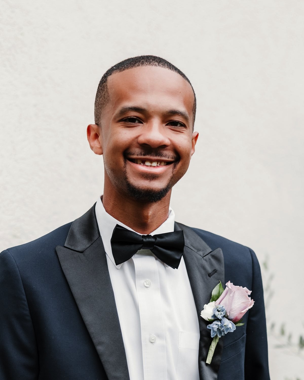 Jaylan Scott smiling at the camera in a navy tuxedo